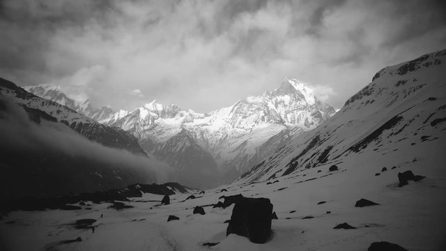 The cloud moving on mountain landscape covered snow, view from Annapurna base camp in black and white tone  