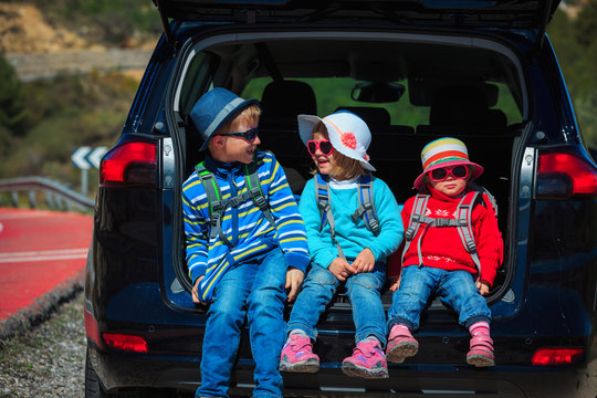 happy kids- little boy and girls- enjoy travel by car