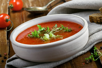 Bowl of gazpacho, bread and vegetables on a table. Tasty Spanish vegan soup. Close-up shot.