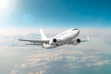 Rolgordijnen zonder boren Passenger white airplane flies in a blue sky with a bright sun. © aapsky