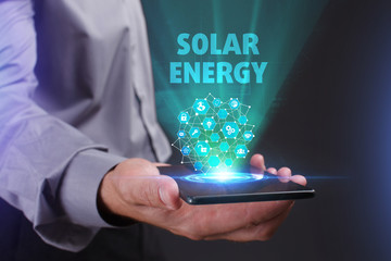 The concept of business, technology, the Internet and the network. A young entrepreneur working on a virtual screen of the future and sees the inscription: Solar energy