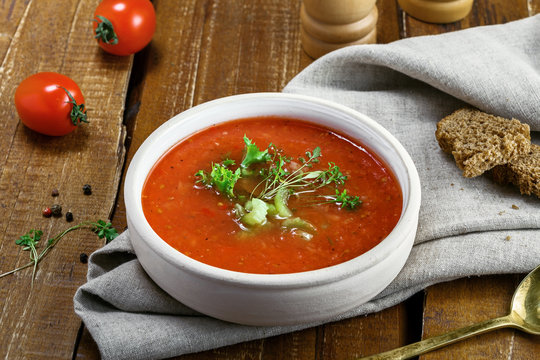 Delicious gazpacho and ingredients on a table. Vegetarian vegetable cold soup.