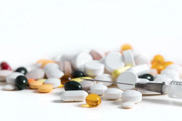 Pills and and syringe on blue background