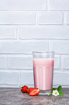 Healthy breakfast. Glass of homemade yogurt and fresh strawberries with spring flowers