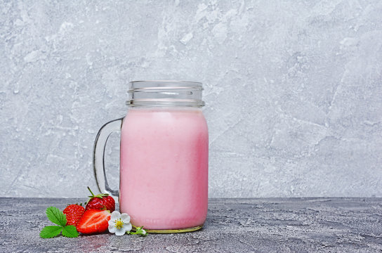 Healthy breakfast. Glass jar of homemade yogurt and fresh strawberries with spring flowers