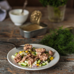 salad with  canned fish, a cucumber, egg and sauce with greens - (meal) - cuisine.  Food background