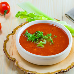 Gazpacho in a bowl, ingredients and bread. Classic Spanish cuisine vegetarian soup.