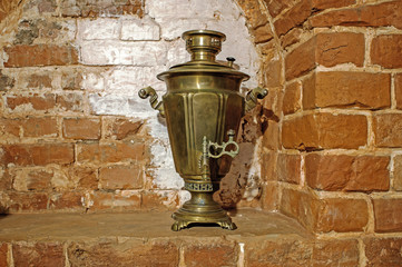 Ancient copper Russian samovar on the background of a red brick oven. Background, retro, vintage - Powered by Adobe