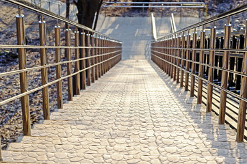Stairs to the Park with steep steps and shiny metal railings. Top view, background