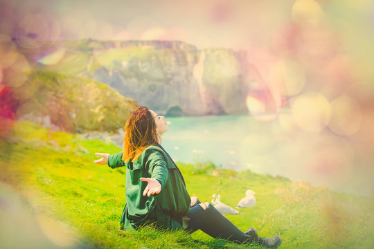 photo of beautiful young woman sitting on the grass and relaxing on the wonderful landmark background