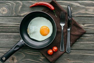Breakfast with fried egg and vegetables on textile napkin