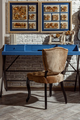 interior of modern retro styled living room with blue table, chair and photos in frames