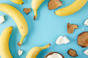 top view of arranged coconut pieces and bananas isolated on blue