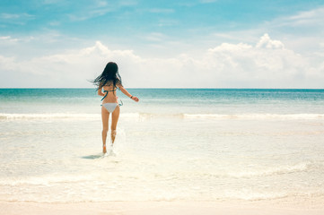 Fototapeta na wymiar Young slim woman running to the sea