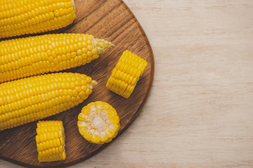 Sweet corns. Fresh corn on cobs on wooden table.
