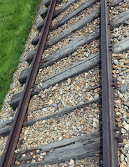 railroad track with the roadbed in rocks and rusty rails