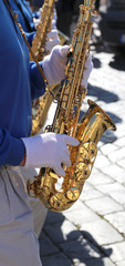 Saxophonist plays the saxophone using white gloves during the mu