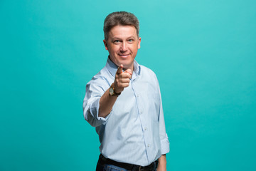 The happy business man point you and want you, half length closeup portrait on blue background.