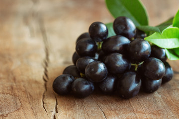 Bunch of fresh seedless red grape on wood table in close up view with copy space for background or wallpaper. Delicious and healthy fruit with sweet taste and juicy suitable for eating and make wine.