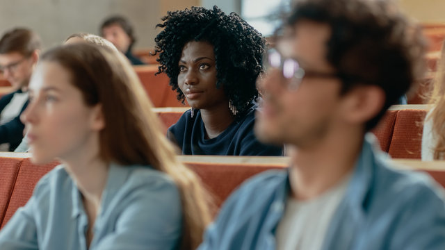 Close-up of a Beautiful Black Female Student Sitting Among Her Fellow Students in the Classroom, She's Listening to a Lecture.