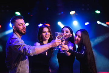 Young attractive women and man celebrating a party, drinking champagne and dancing. Birthday party.