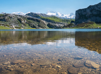 Mountain lake and peaks covered with the snow.