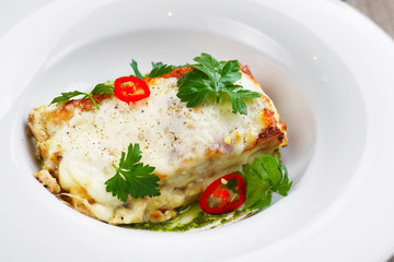 Delicious traditional italian food, lasagna with mozzarella cheese, pesto sauce and parsley leaves. Mediterranean cuisine, appetizer, banquet, restaurant menu, dining concept