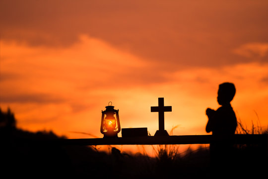 Boy Praying To God With Oil Lamp And Cross, Christian Concept