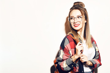 Young blonde student girl looking at camera. Education, training. Cool hipster student woman. Fashion pretty young woman in glasses over white background. Lifestyle and people concept. Having fun