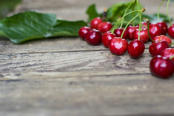 Freshly picked, delicious  cherries on old wooden table with copy space
