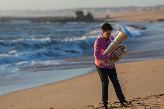 Musician play Tuba on the ocean coast.