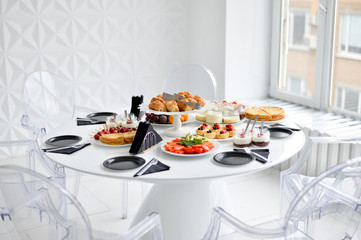 Beautiful european buffet. A lot of food for breakfast. White table. 