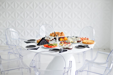 Beautiful european breakfast. A lot of food. Cakes and drinks. White table. 