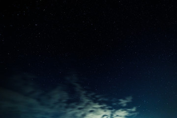 Fototapeta na wymiar Starry sky and illuminated clouds.