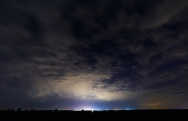 Starry sky and illuminated clouds.