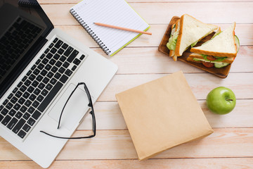 Lunch bag with sandwich and fruits in office table