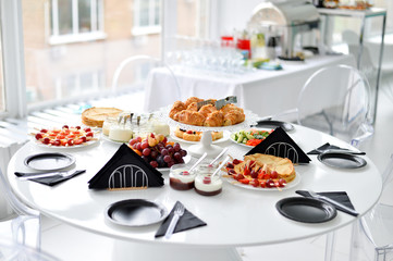 Beautiful breakfast. A lot of food. European breakfast. White table. 