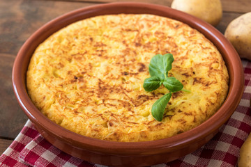 Traditional spanish omelette close up,  view from above. Spanish tortilla on a rustic wooden texture with a place for text.