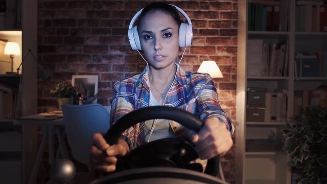 Woman playing a car race videogame using a racing controller