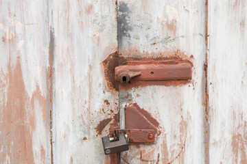 Old rusty padlock on the metal door