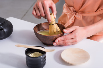 partial view of woman having tea ceremony in morning at home