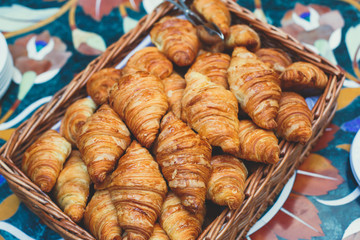 Beautifully decorated catering banquet table with variety of different pastry and bakery, with croissants and cookies on corporate christmas birthday party event or wedding celebration