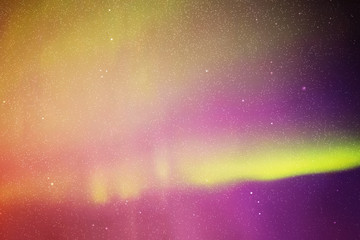 Night starry sky. Northern lights. Purple yellow aurora borealis