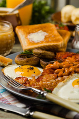 Full English breakfast, with sausage, mushrooms, beans and a fried egg.