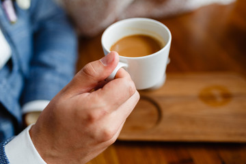 Close up of arms of successful business having a business meeting with his client in cafe. The man in suit is drinking coffee. Morning Breakfast at the hotel.