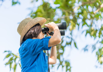 Close up Woman wear hat and hold binocular in grass field
