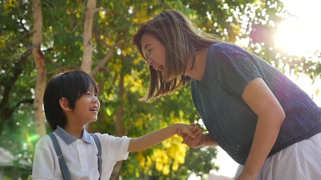 Asian mother  saying goodbye to her son as he leave for School,back to school concept slow motion 