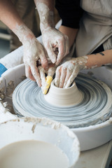 Handcrafted on a potter's wheel,Hands make clay from various items for home and sale in the store and at the exhibition, ceramic items are made in hand, the clay billet becomes a ceramic dish