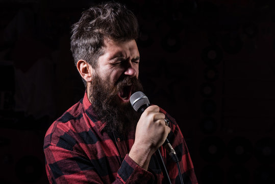 Talent Show Concept. Man With Tense Face Holds Microphone,