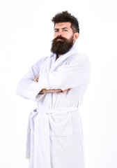 Full length portrait of a young man in a bathrobe isolated on white background. Guy standing with arms crossed at his chest. Perfect morning concept